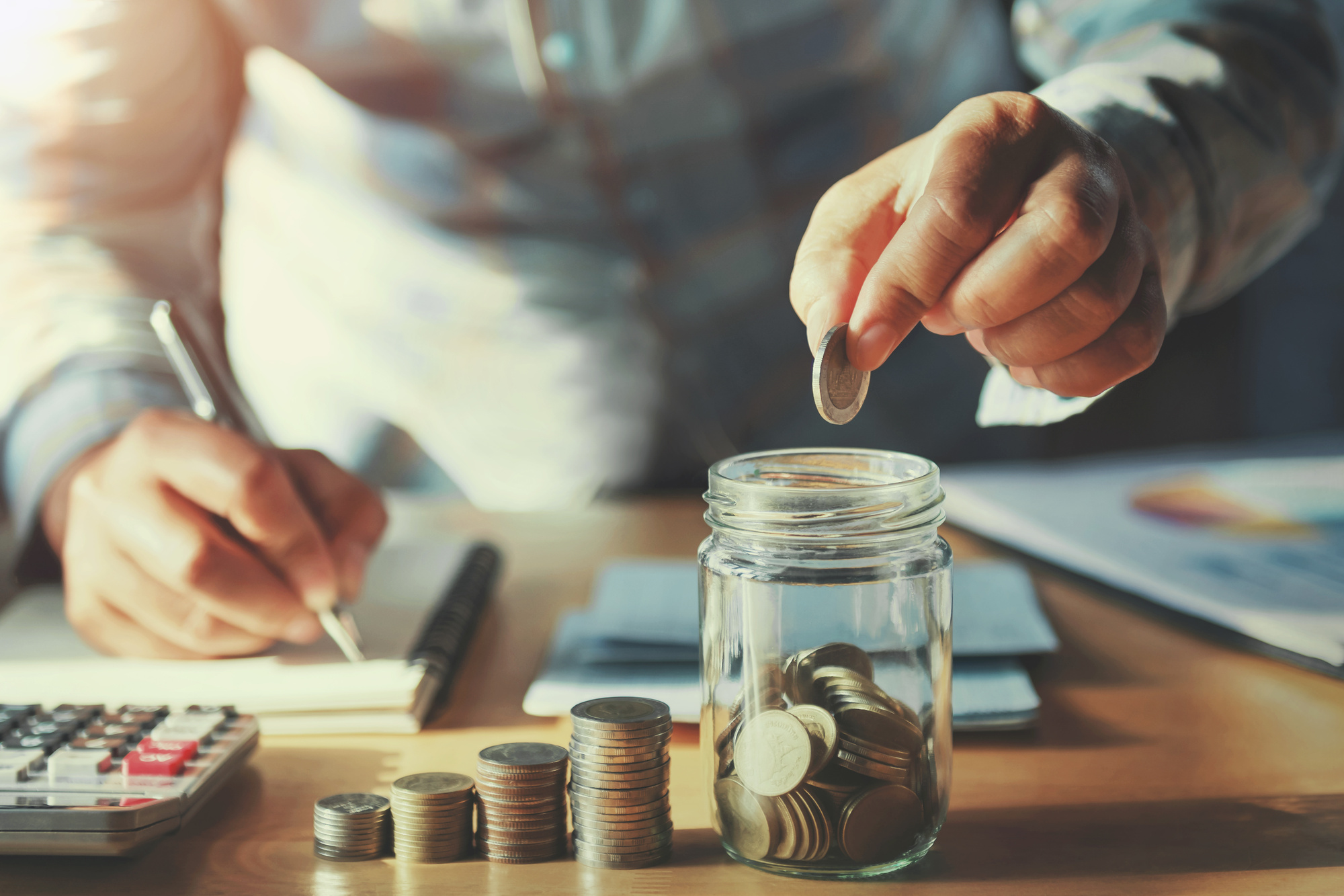 businessman saving money concept. hand holding coins putting in